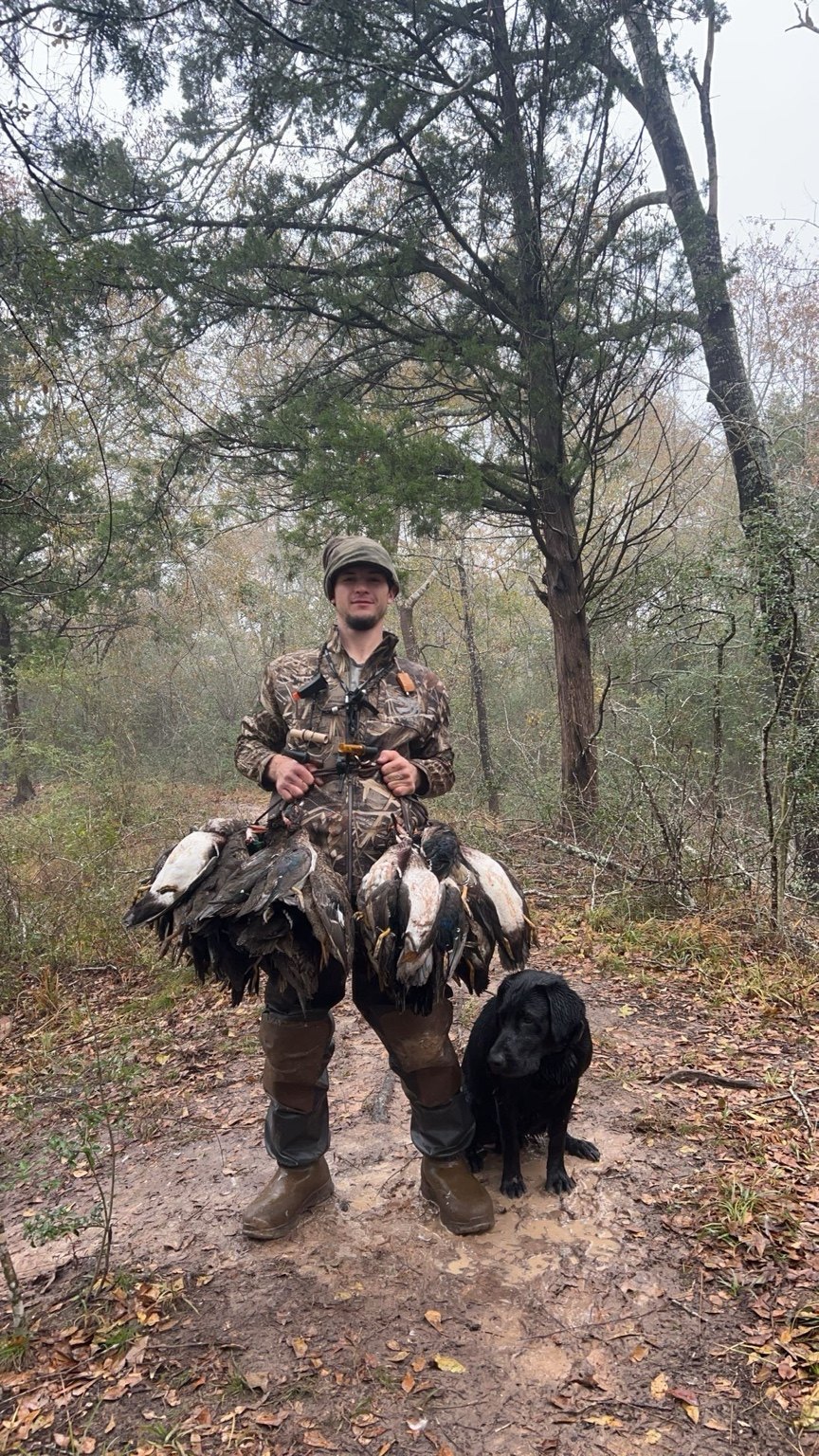 Jeffrey Neu outdoors after a waterfowl hunt with his black Labrador retriever